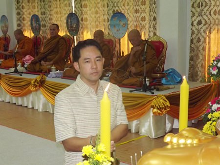 Mayor Itthiphol Kunplome lights candles during the auspicious ceremony.