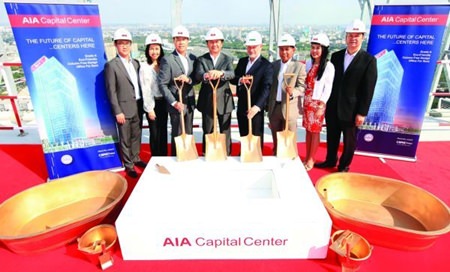 AIA executives pose for a photo on the roof of the AIA Capital Center in Bangkok during the building’s topping out ceremony.