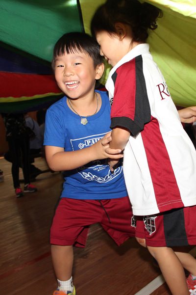 Smiles and laughter as student’s enjoy the parachute game.