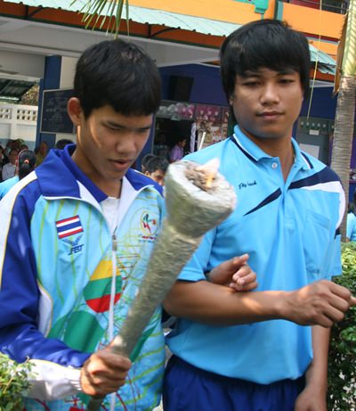 A student prepares to light the flame to open the games.