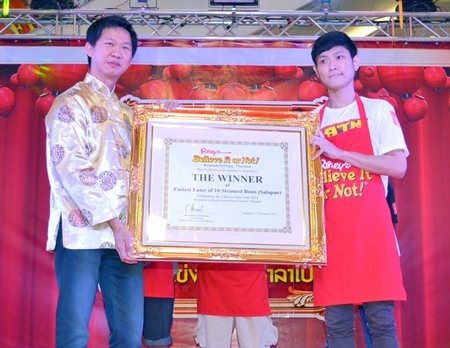 Somporn Naksuetrong (left), manager of Ripley’s Pattaya, presents the winning plaque to Akharin Jatuporn.