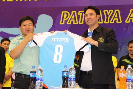 Nipitchon Ketpongpat, president of Pattaya Arena Futsal Club (left) presents a Pattaya Arena jersey to mayor Ittipol Kunplome at the press conference to launch the new Futsal team, held Tuesday, Feb. 18 at the Indoor stadium in Soi Chaiyapruek 2.