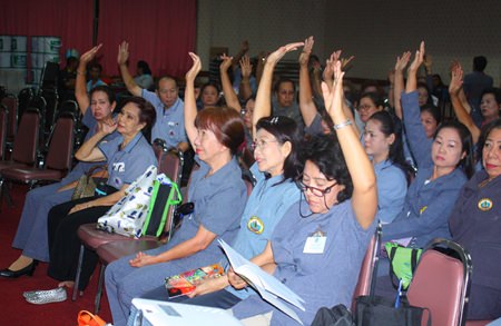 Pattaya Public health volunteers members raise their hands to approve Suphin Ruangrung as the next president of Pattaya Public Health Volunteers.
