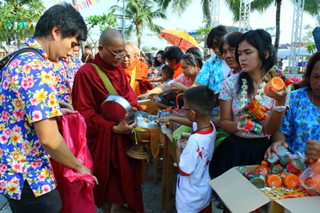 The quieter side of Songkran - Citizens present alms to monks, offering rice and dried food at Lan Po Public Park.