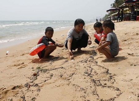 Mother Apaporn Somjai, 22, brought her children to play in the ocean but quickly pulled them out when she noticed the oil.