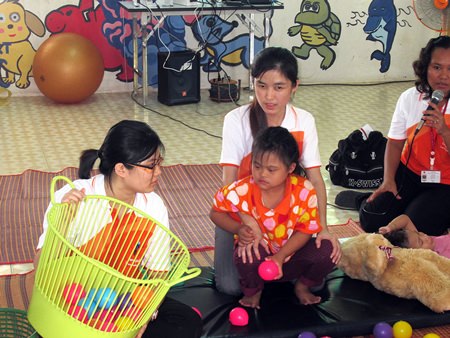 Karuna Piromtan (right, with microphone), seen here with two teachers and an autistic child, is a supervisor of therapy education from the Ministry of Education in Chonburi.
