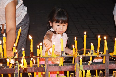 N’Imjai learns how to place candles in the prayer area after completing her 3 Wien Thien rounds.