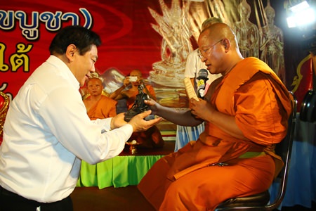 Chanyuth Hengtrakul (left), advisor to the Ministry of Education, accepts a Dr. Jivaka Kumar Bhacca statuette from Phra Punya Rattanaporn, abbot of Wat Chaimongkol Phra Aaramluang.