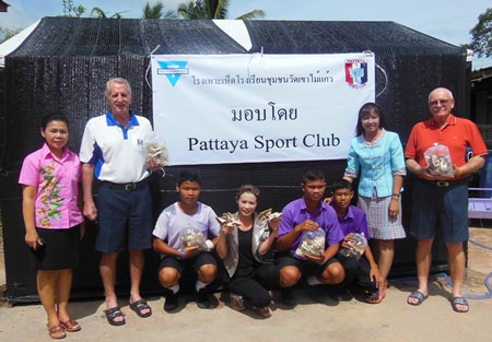 Members of the YWCA and Pattaya Sports Club pose with students and teachers in front of one of the many farms.