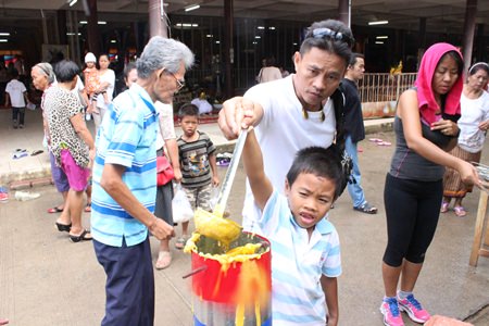 Father & son cast candles together to increase brightness in their lives and to instill the importance of Thai traditions in the next generation at Wat Bunsamphan.
