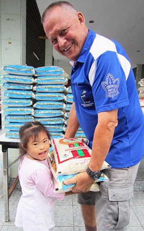 Bill hands out rice to families  with disabled children in Nongprue.