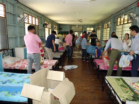 After donating bedding and sporting goods to the Banglamung Home for Boys, members of the South Korean Thai Aridang Association help change bed sheets and clean the fans in the dormitory.