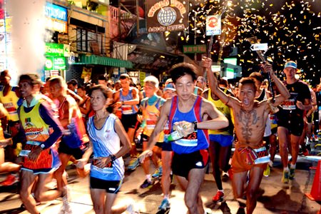 Runners sprint over the line at 3:45 a.m. for the start of the full marathon race.