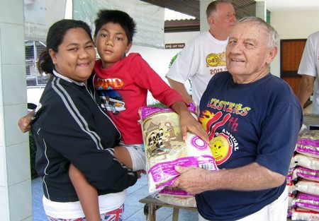 Nathawat, shown here with Bernie and Erle during the monthly rice distribution, had out grown his wheelchair, compelling his mother to try and carry him around.