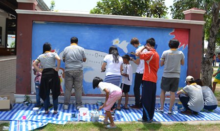 This group helps children paint a mural of a huge airplane on the Benefactors Wall.