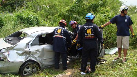 Experts work to extricate the victims after their car was struck by a State Railway of Thailand train at an unmarked crossing in Nong Sadao in Banglamung District.