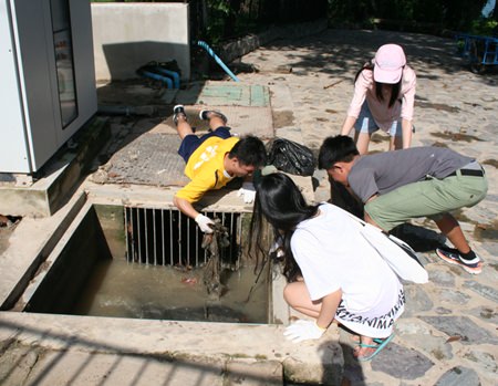 Students dig deep to clean the drains.
