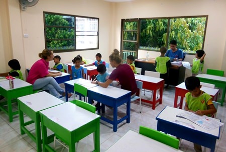 Here, volunteers are teaching the children to read and write.