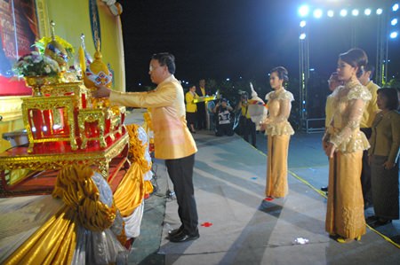 Apichart Thepnoo, Chief Judge of the Pattaya Provincial Court, places gold and silver floral ornaments in front of His Majesty’s portrait at Bali Hai Pier.
