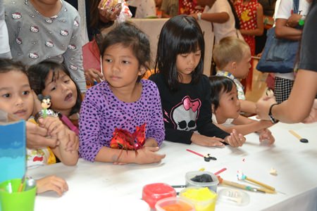 Youngsters prepare for the coloring books to be brought out in the coloring booths at Central Festival Pattaya Beach.