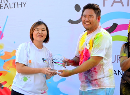 TAT Pattaya Director Suladda Sarutilavan (left) presents a prize to a runner from Bangkok who heard about the Colour Run via Facebook