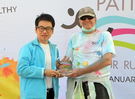 Chairman of Tourism & Sports Rattanachai Sutidechanai presents a trophy to Donald Maclaughlin (right) aged 76 the winner of the oldest runner prize.