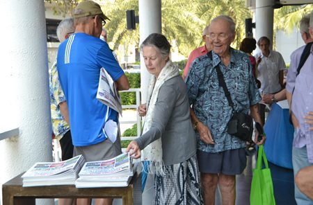 Attendees at the PCEC Sunday meeting pick up their free copy of Pattaya Mail, which is available at the end of the meeting.