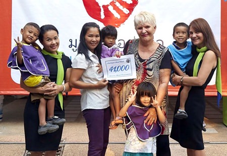 Eva Johnson (centre right), a co-founder of the Pattaya Soul Club, and flanked by Min (far left) and Janey (far right) of the Riviera Group, presents a cheque for 41,000 baht to Kh. Pai, the President of the Hand to Hand Foundation (centre left) along with children under the care of the organisation.