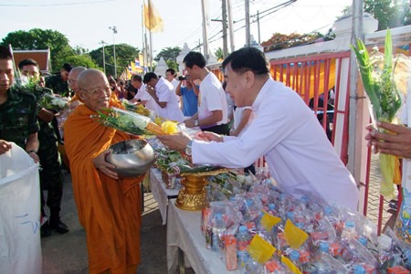 Chonburi residents offer alms to a procession of monks in the morning.