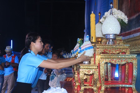Pattaya Mail’s Nutsara Duangsri places our flower cone in front of an image of HM the Queen.