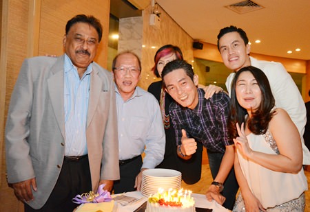 Friends gather around Sanphet ‘Mod’ Suphabuansathien as he prepares to blow out the candles on his birthday cake.