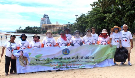 Australian tourist Bob Borgiani (far right) poses on Pattaya Beach with workers from the clean-up team sent by city hall, Wednesday, August 5.