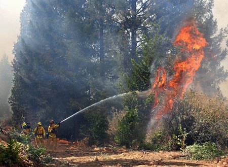 In this Sept. 17, 2014 file photo, firefighters battle the flames from the King fire near Fresh Pond, Calif. New scientific analysis shows the fingerprints of manmade climate change on 14 extreme weather events in 2014, hitting every continent but Antarctica. (AP Photo/Rich Pedroncelli, File)