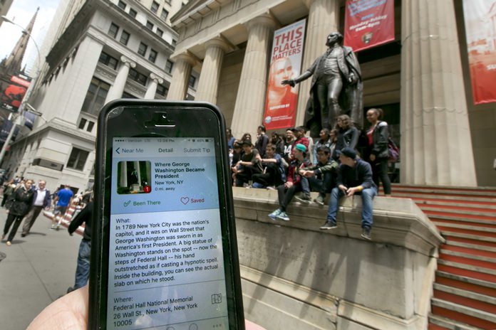 In this Tuesday, May 24, 2016, photo, the Roadside Presidents smartphone app directs people to the statue of George Washington on the steps of the Federal Hall National Monument, in New York’s Financial District. Heading out for a holiday weekend road trip? There are a number of apps available to entertain and educate along the way. (AP Photo/Richard Drew)