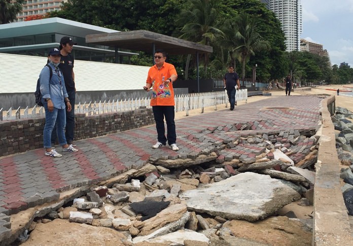 Deputy Mayor Verawat Khakhay inspects pavement and bricks along a walkway at Wong Amat Beach that sustained heavy damage from recent storms.