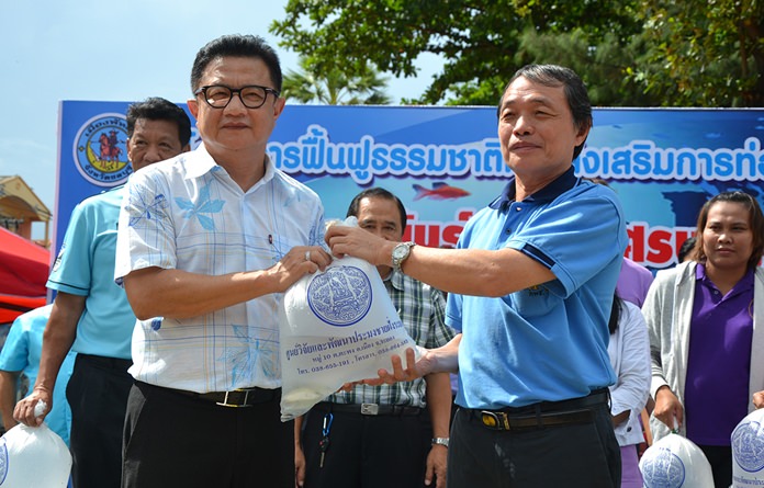 Jaroen Reunghataidhamma (right), director of the Rayong Coastal Fisheries Research and Development Center, presents fish to Deputy Mayor Wutisak Rermkitkarn on the occasion of World Environment Day.