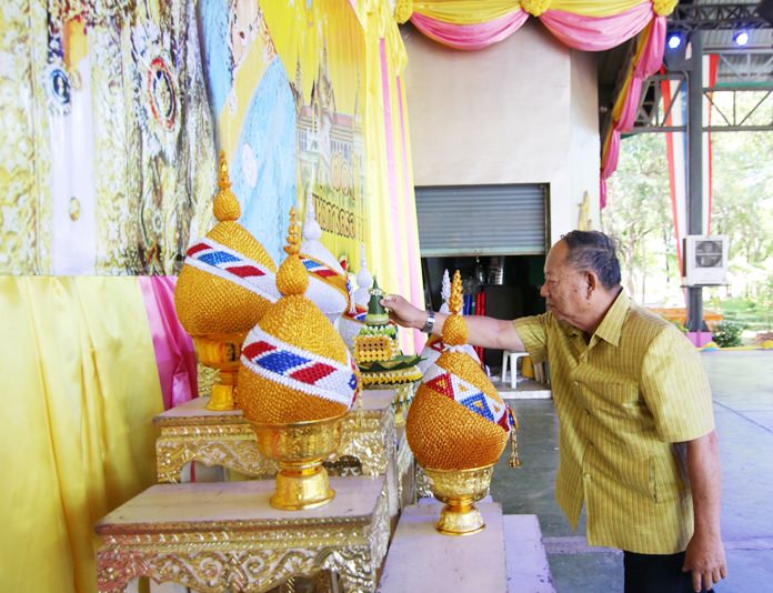Nongprue Mayor Mai Chaiyanit presents flower cones before a portrait of His Majesty the King.