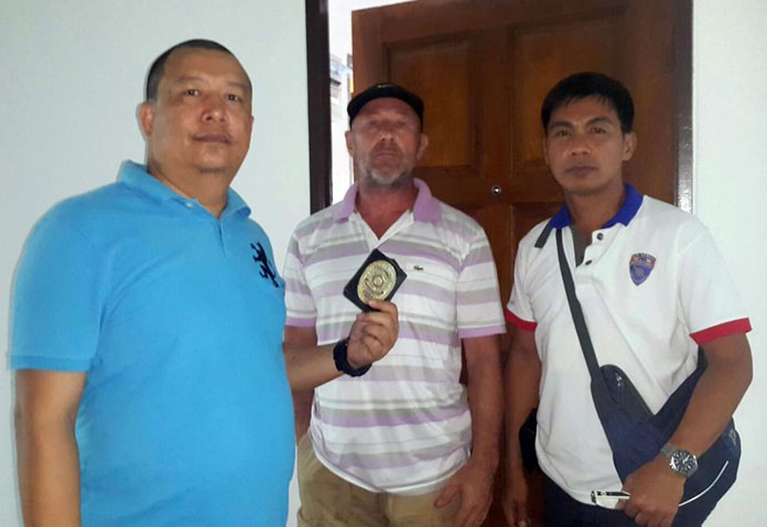 Andrew Ronald Matthews (center) was taken into custody by Chonburi immigration police at his View Talay condominium in Jomtien Beach on charges of defaming and harassing Thai nationals online.
