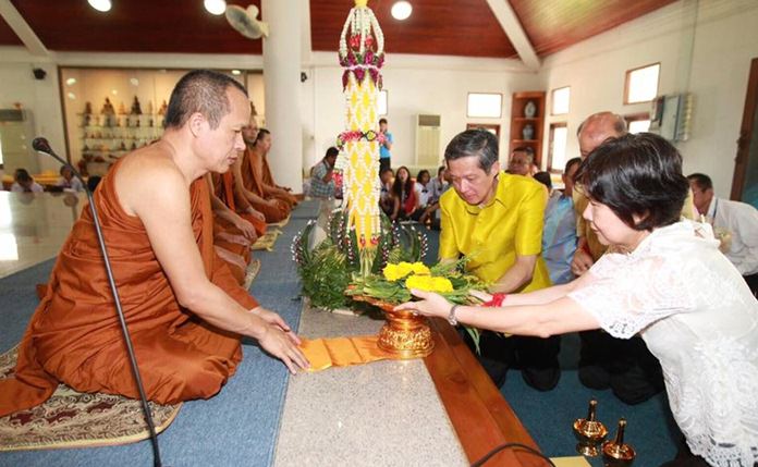 Interim Pattaya Mayor Chanatpong Sriviset and local officials present candles and offerings to monk at Wat Chonglom in Naklua.