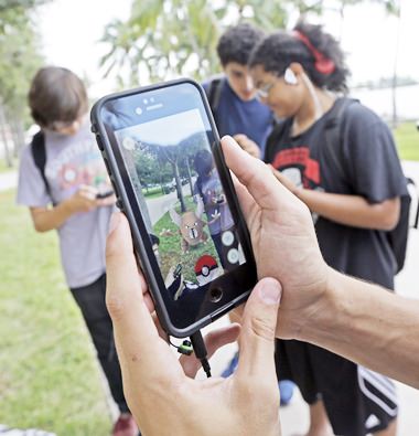 In this Tuesday, July 12, 2016, file photo, Pinsir, a Pokemon, is found by a group of Pokemon Go players at Bayfront Park in downtown Miami. The “Pokemon Go” craze has sent legions of players hiking around cities and battling with “pocket monsters” on their smartphones. (AP Photo/Alan Diaz, File)