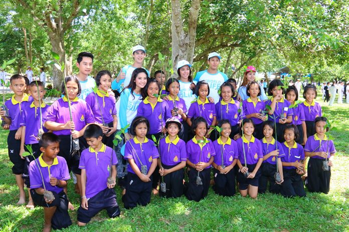 Celebrities pose with school children before the latter rolled up their pant legs and planted mangroves in the mud.