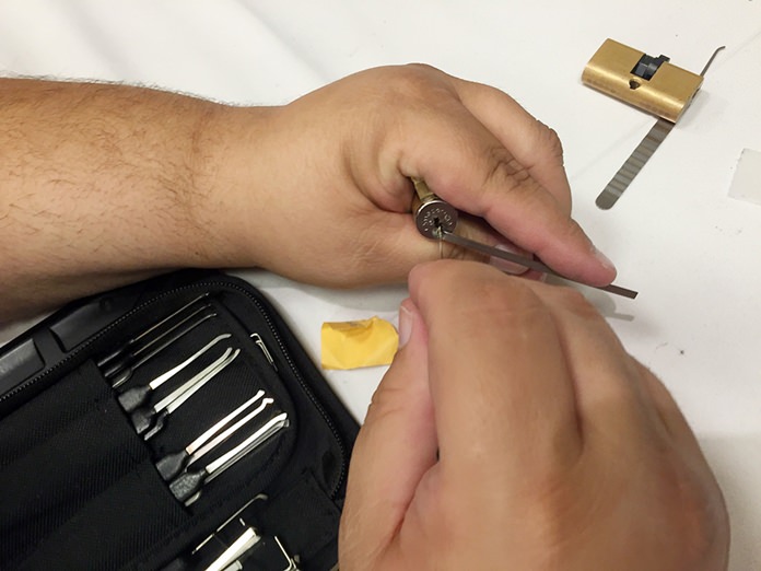 In this Sunday, Aug. 7, 2016, photo, a Def Con attendee demonstrates how to pick a padlock at the annual Def Con conference in Las Vegas. Picking locks might seem out of place at a cybersecurity gathering, but it’s an important skill for those tasked with protecting machines from digital threats. (AP Photo/Bree Fowler)