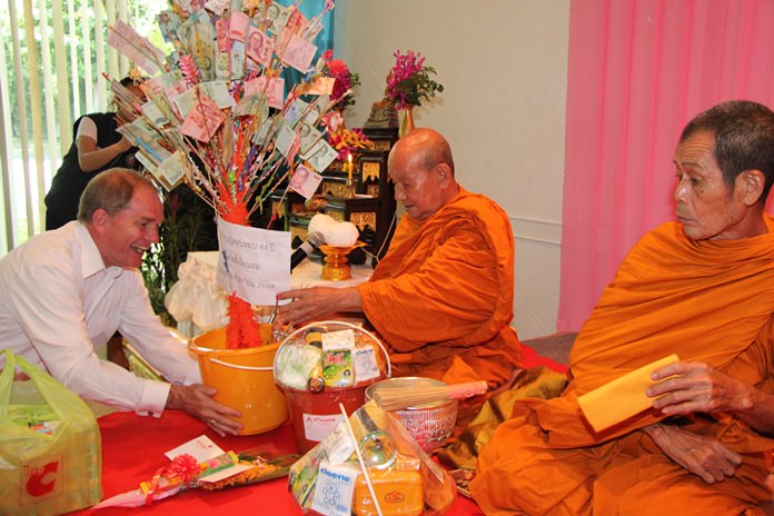 Robert Rijnders (left) lead the Amari staff in presenting alms to revered monks invited for the ceremony.