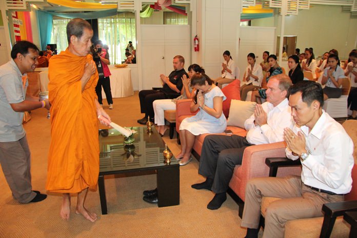 A most revered monk blesses the assembled audience with holy water.