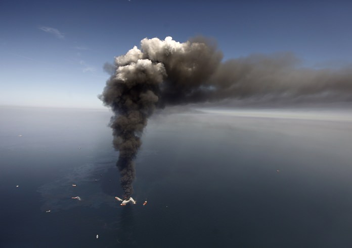 This April 21, 2010, file photo shows a large plume of smoke rising from BP’s Deepwater Horizon offshore oil rig in the Gulf of Mexico. (AP Photo/Gerald Herbert)