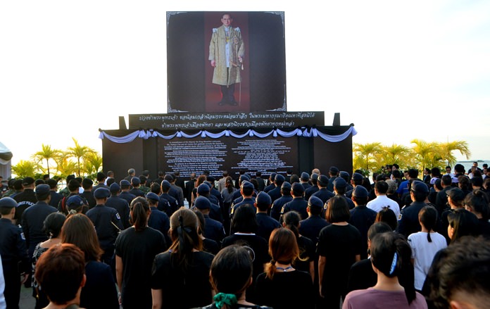 The public in pays tribute to the late His Majesty the King by singing the royal anthem on Pattaya Beach.