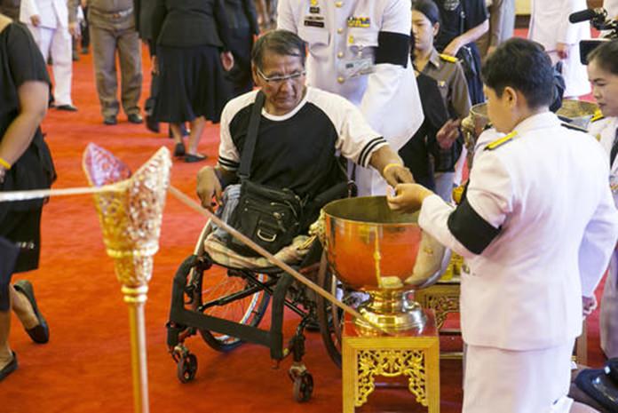 A mourner, center, pours holy water into a bowl as part of a bathing ceremony for Thai King Bhumibol Adulyadej at the Grand Palace in Bangkok. (AP Photo/Wason Wanichakorn)