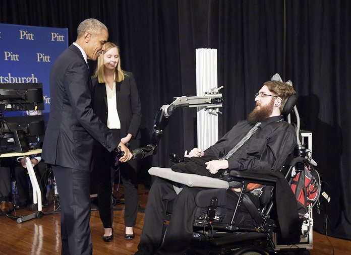 President Barack Obama, left, shakes hands with Nathan Copeland, right, during a tour of innovation projects at the White House Frontiers Conference at University of Pittsburgh in Pittsburgh, Thursday, Oct. 13. (AP Photo/Susan Walsh)