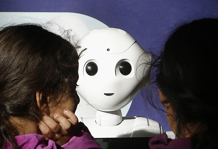 Laila, left, and her sister Nour, last names not given, play with Pepper the robot at Westfield Mall in San Francisco. (AP Photo/Jeff Chiu)