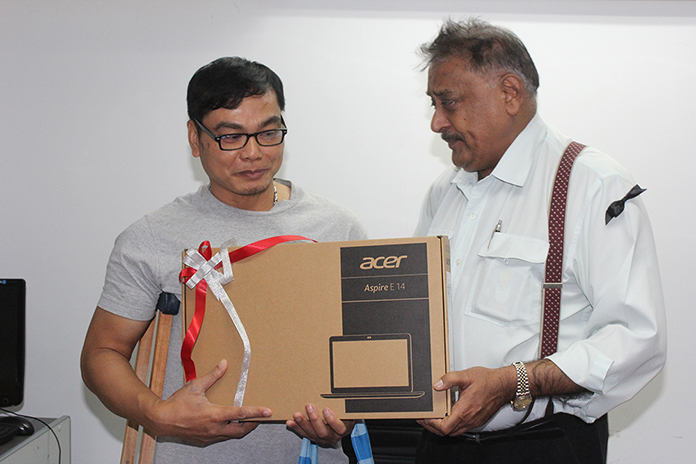 On behalf of all the employees, Peter Malhotra presents Nathakorn with a notebook computer as a parting gift.